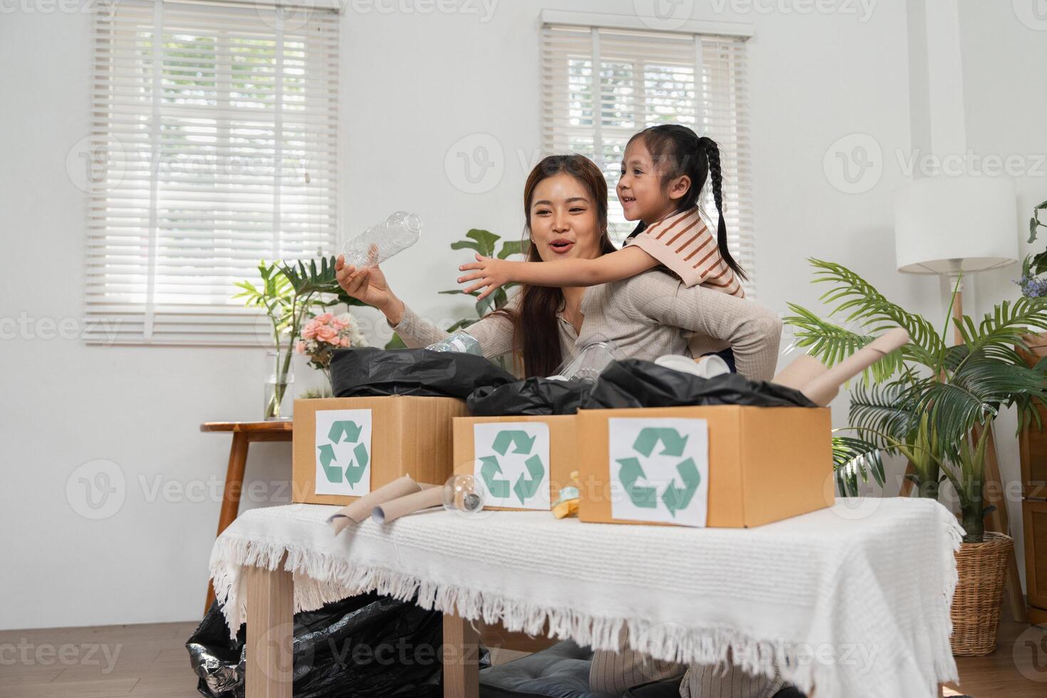 Recycling and Motherhood. A mother demonstrates the importance of recycling while having fun with her daughter. photo