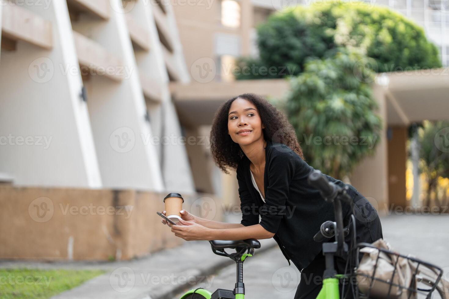 Sustainable Living and Daily Routines. A thoughtful woman leaning on her green bicycle while enjoying a coffee break in a city landscape. photo