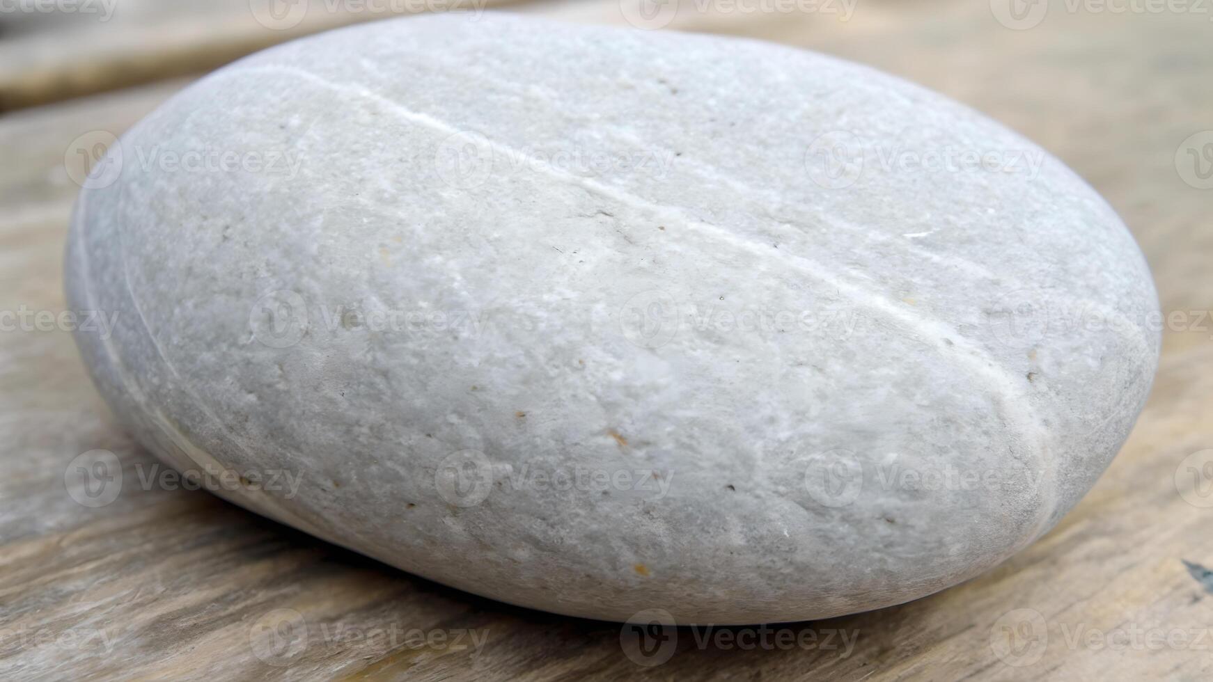 Smooth gray stone resting on wooden surface for nature enthusiasts and interior design inspiration photo