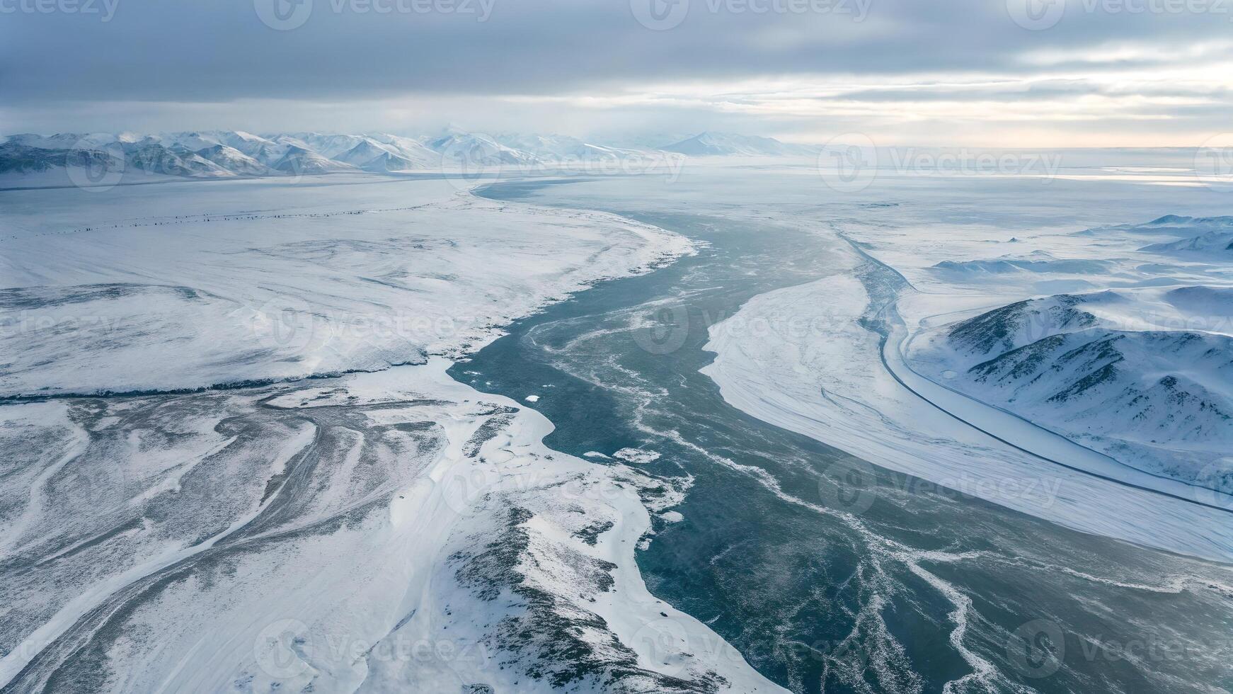Aerial View of Snowy Landscape with Frozen River and Mountain Range for Nature Enthusiasts photo