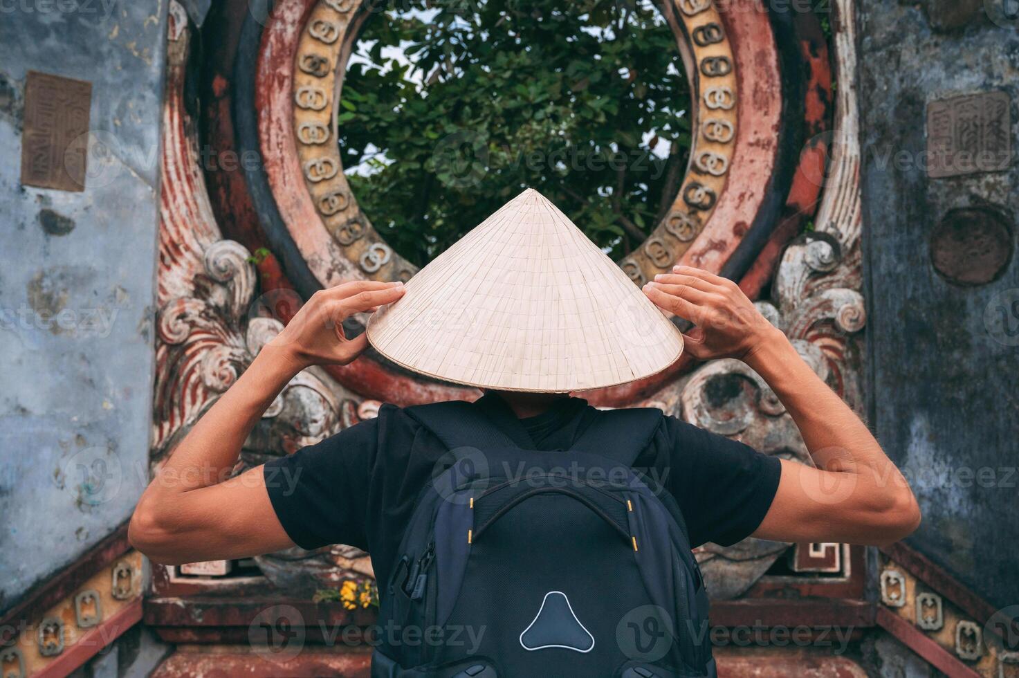 Young man praying at Buddhist temple during Spring Festival in old district of hoi an, back view photo