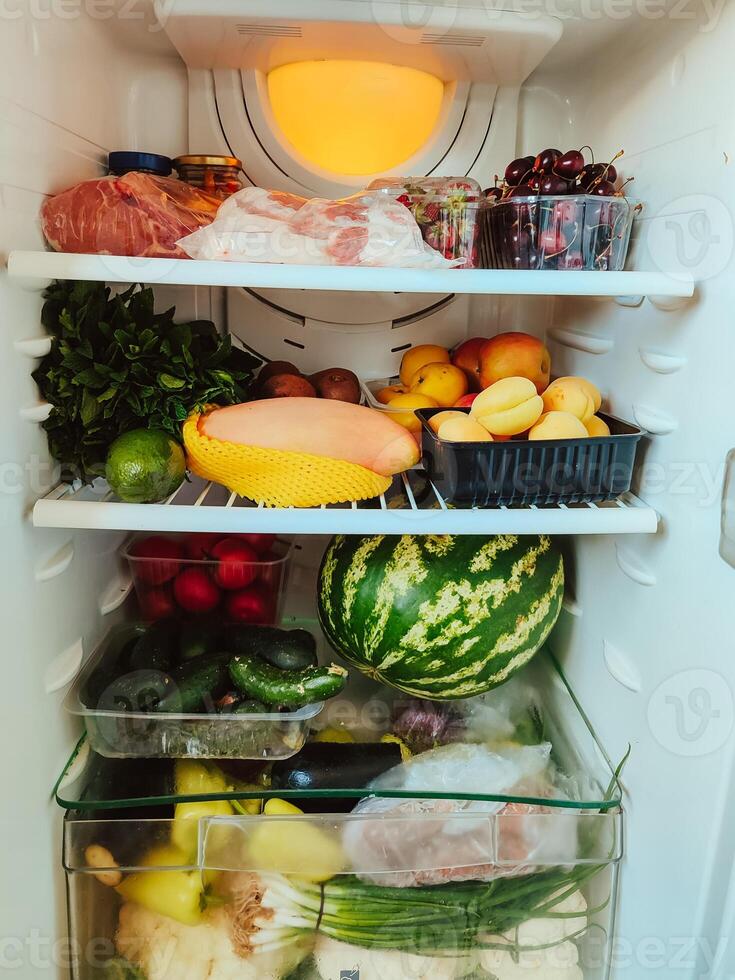 Open refrigerator full of many different products photo