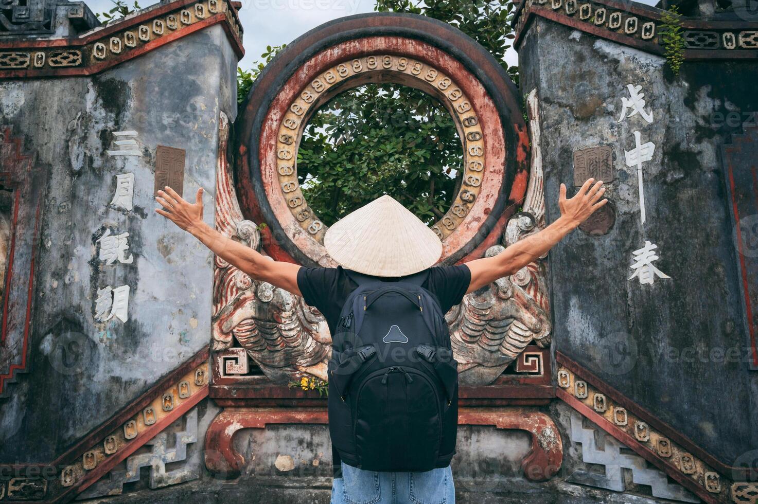 Young man praying at Buddhist temple during Spring Festival in old district of hoi an, back view photo