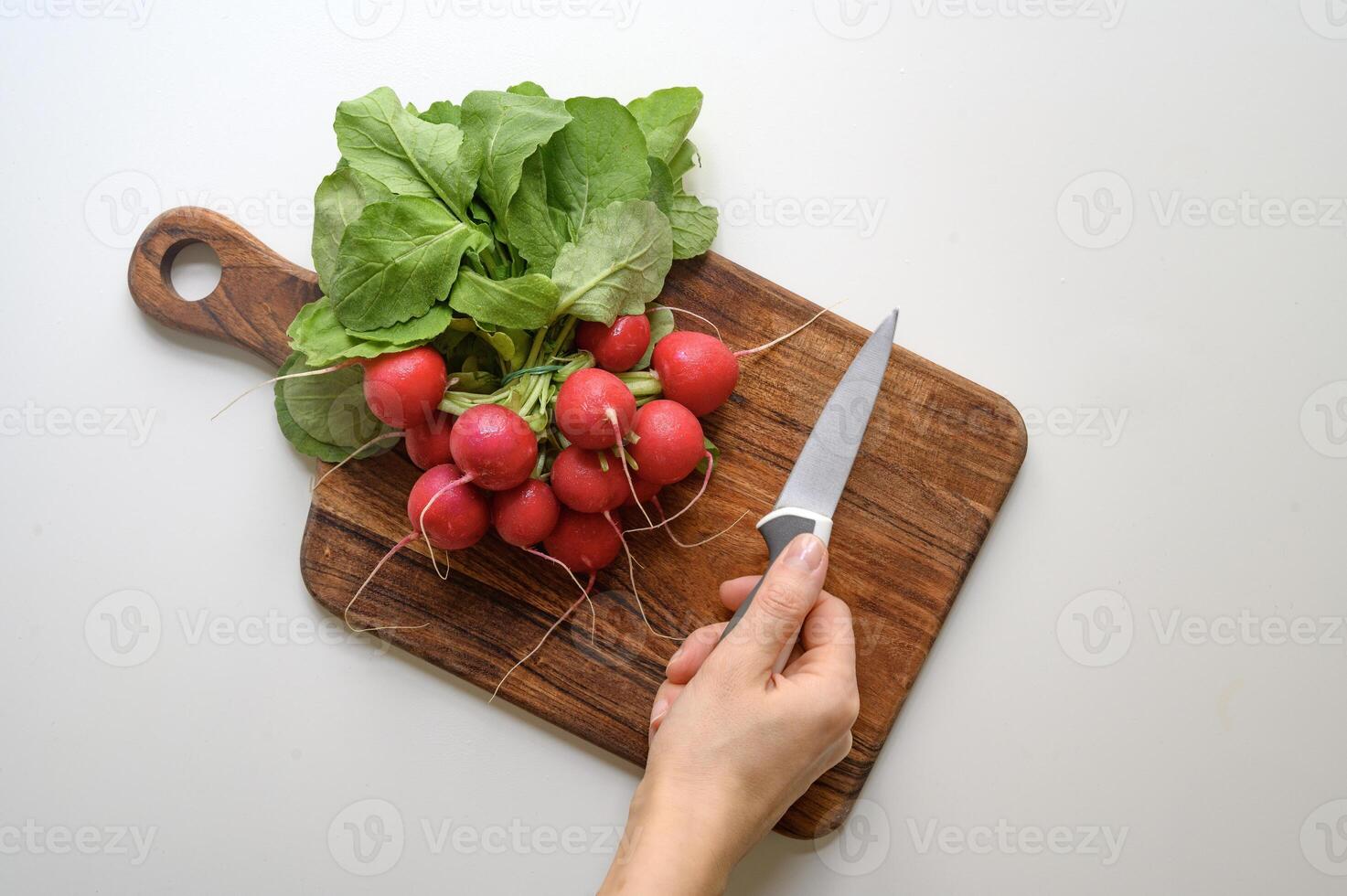 Preparing healthy food or a salad. Radish and knife on chopping board on table. photo