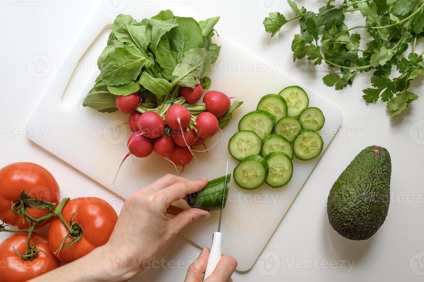 Hands preparing healthy food or salad. Fresh vegetables and herbs on the table. photo