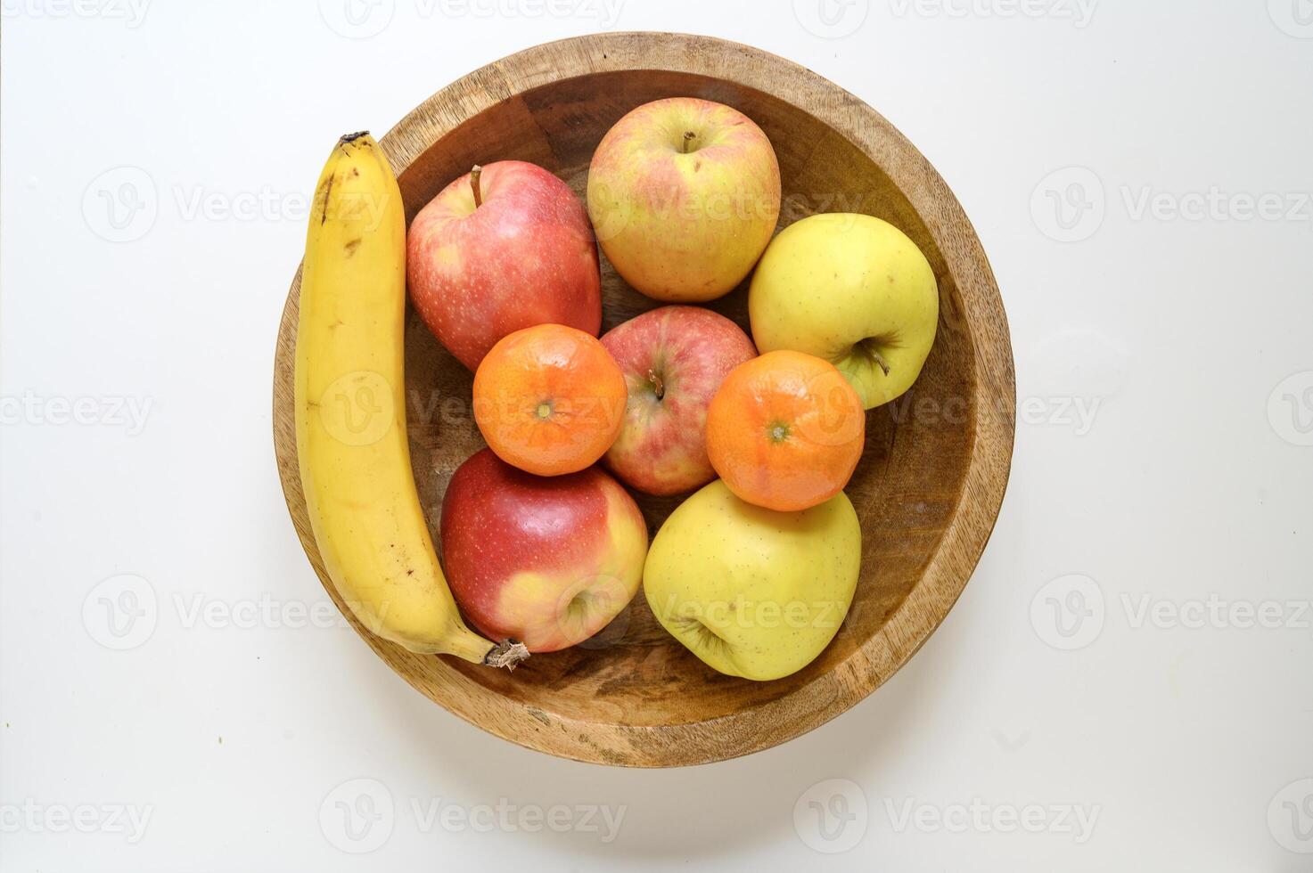Healthy food. A bowl of fruits on the table banana apples citrus. Flat lay. photo