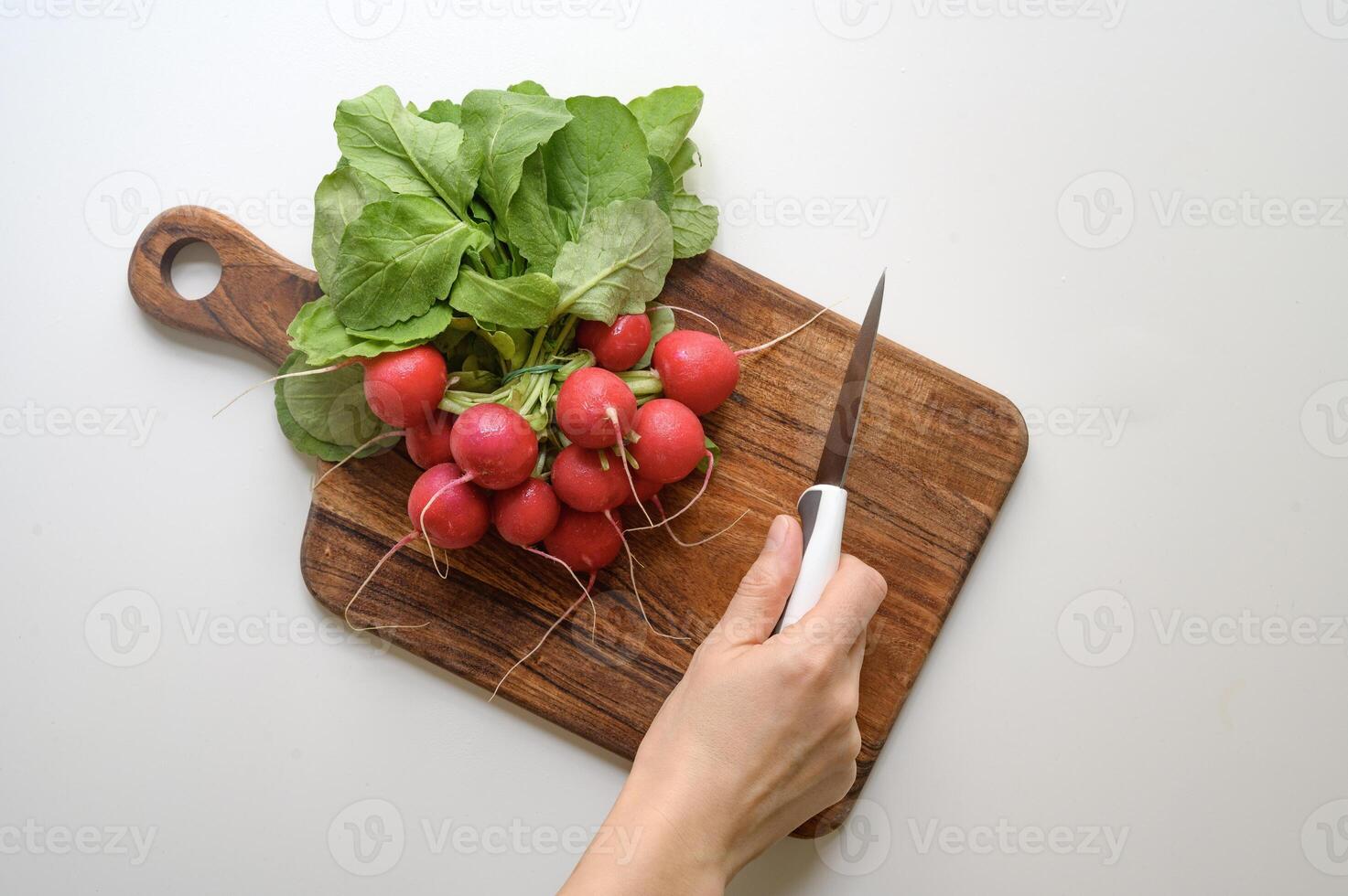 Preparing healthy food or a salad. Radish and knife on chopping board on table. photo