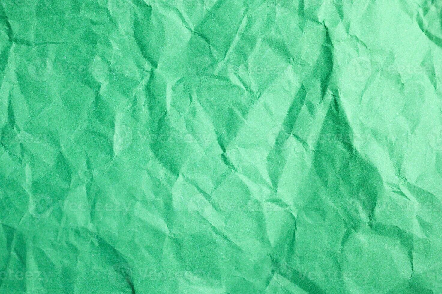 Full frame shot of crumpled green paper sheet texture and background. photo