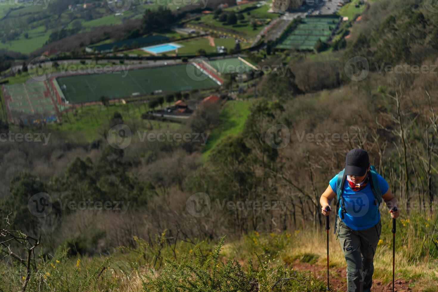 Woman in impressive climb of Naranco mountain, while seeing a part of the natural landscape and the city in the background. photo
