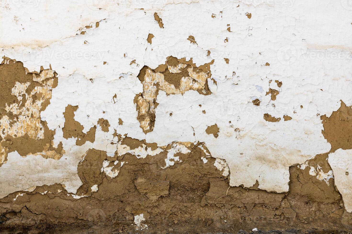 Textured adobe Wall with Peeling White Plaster That Exhibits a Unique and Rustic Feel and Charm photo