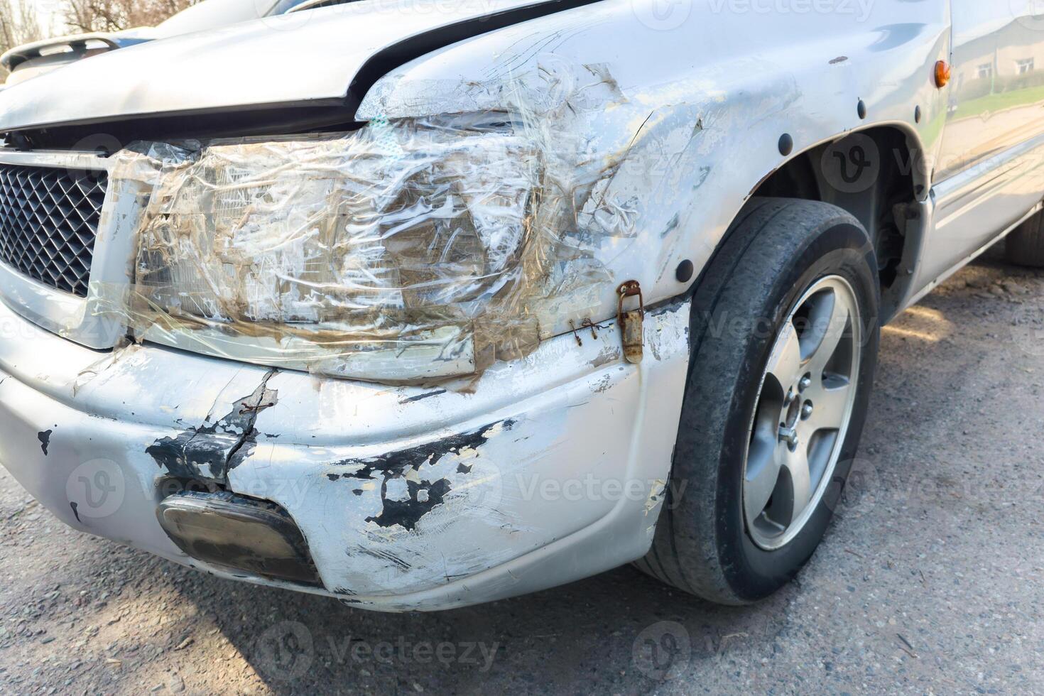 front side of an old damaged white vehicle headlamp fixed with clear tape photo