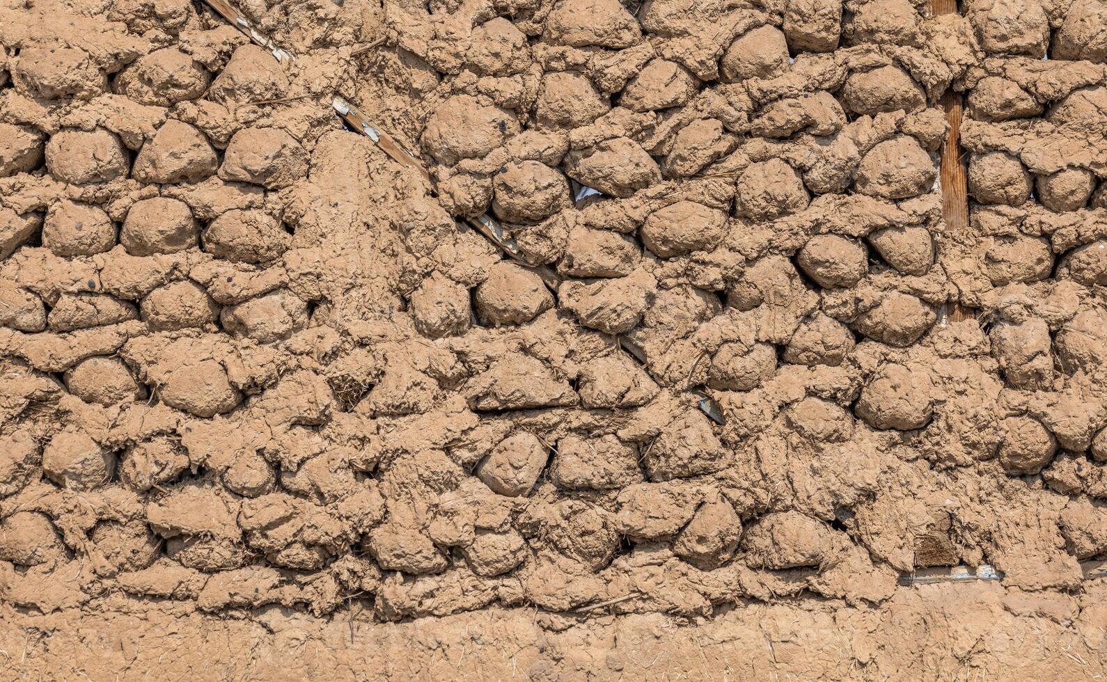 saman adobe wall made with round bricks, texture and background photo