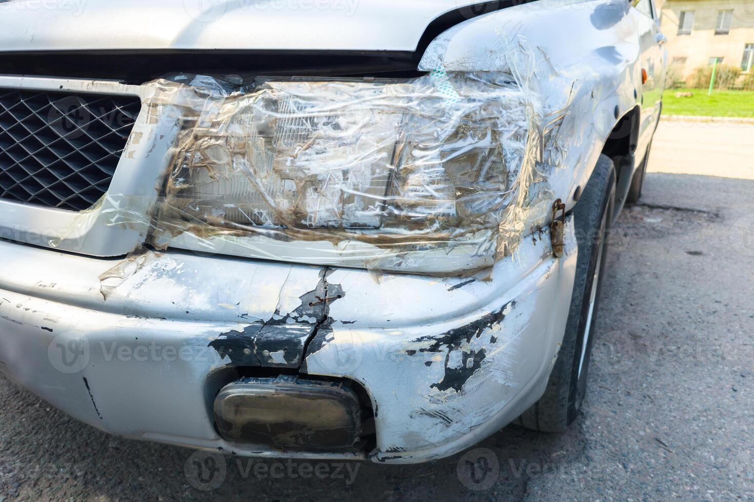 front side of an old damaged white vehicle headlamp fixed with clear tape photo