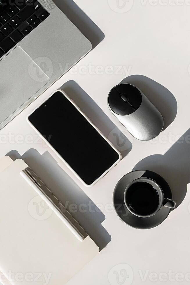 Laptop, Smartphone And Coffee Cup Arranged On Work Desk. photo