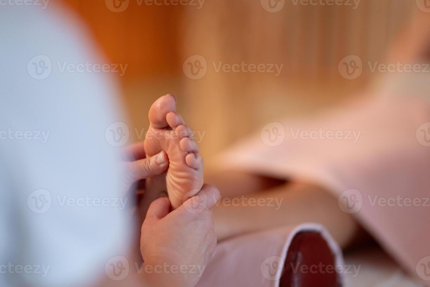 Foot Massage Therapy in a Relaxing Spa Setting. A professional massage therapist in a white uniform provides a soothing foot massage to a client in a calm and serene spa environment photo