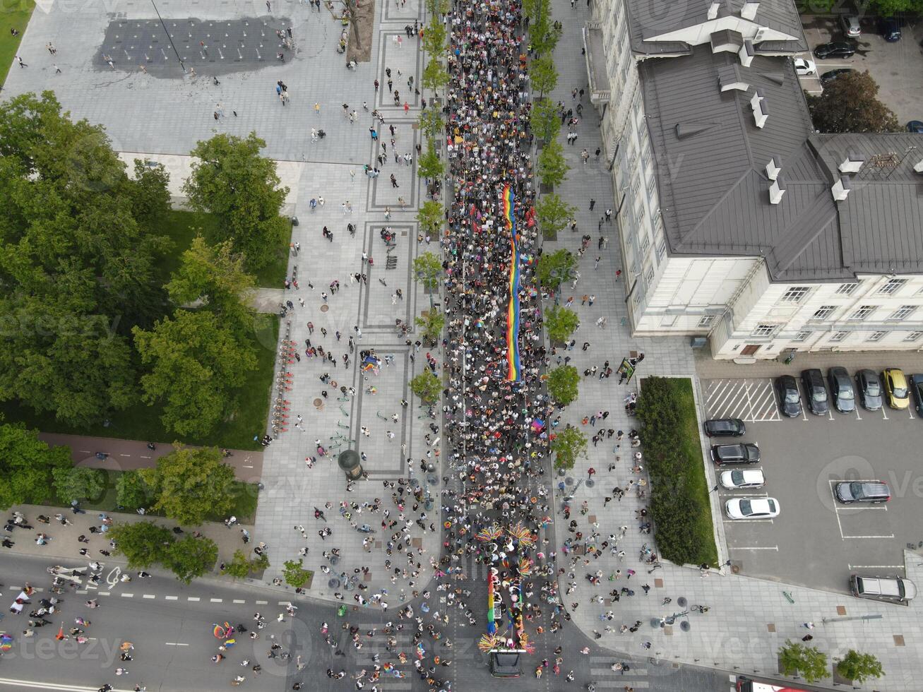 Aerial view of a large crowd marching in a city street during a public demonstration. Protest and social movement concept photo