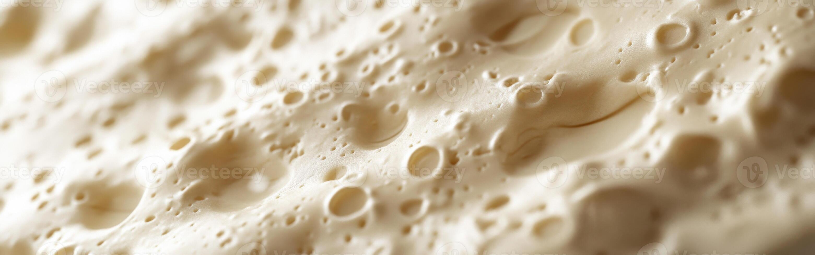 Soft cheese with smooth texture and varied surface features close-up photo