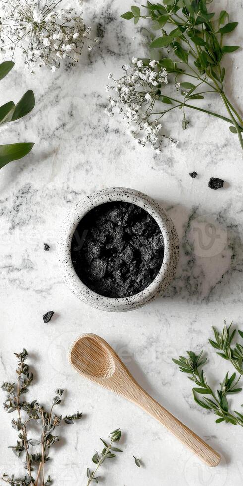 Shilajit resin in a decorative bowl on a marble surface with herbs photo