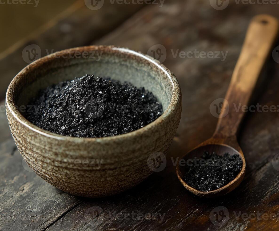 Shilajit powder in a bowl with a wooden spoon on a rustic table photo