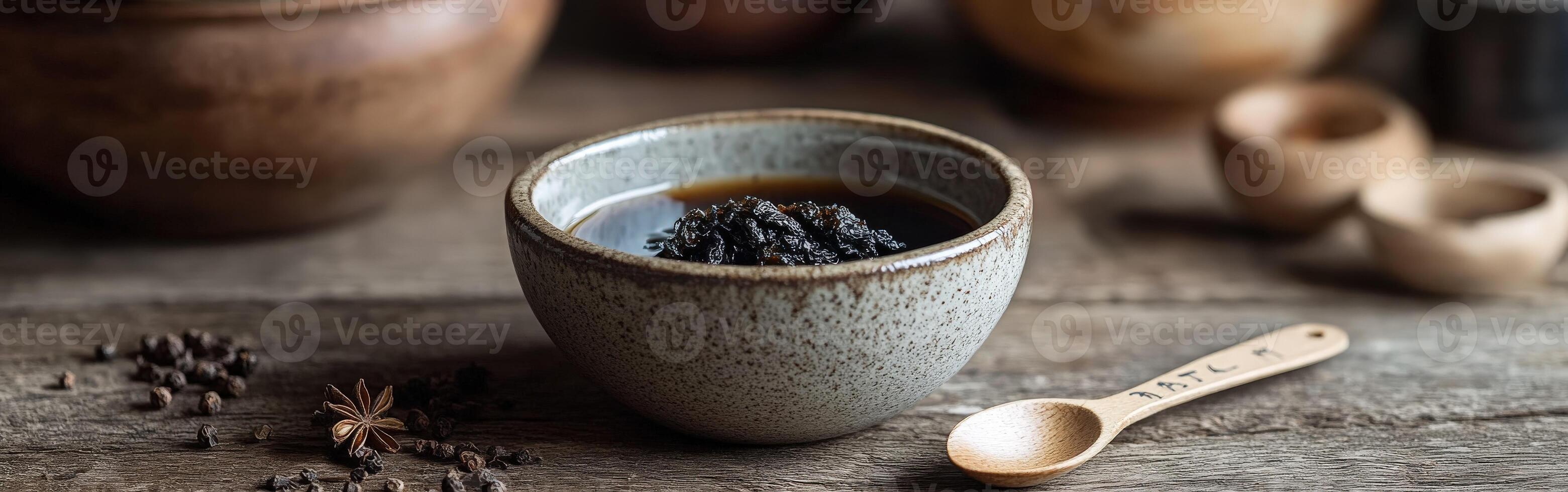 Shilajit resin in a ceramic bowl on a rustic wooden table photo