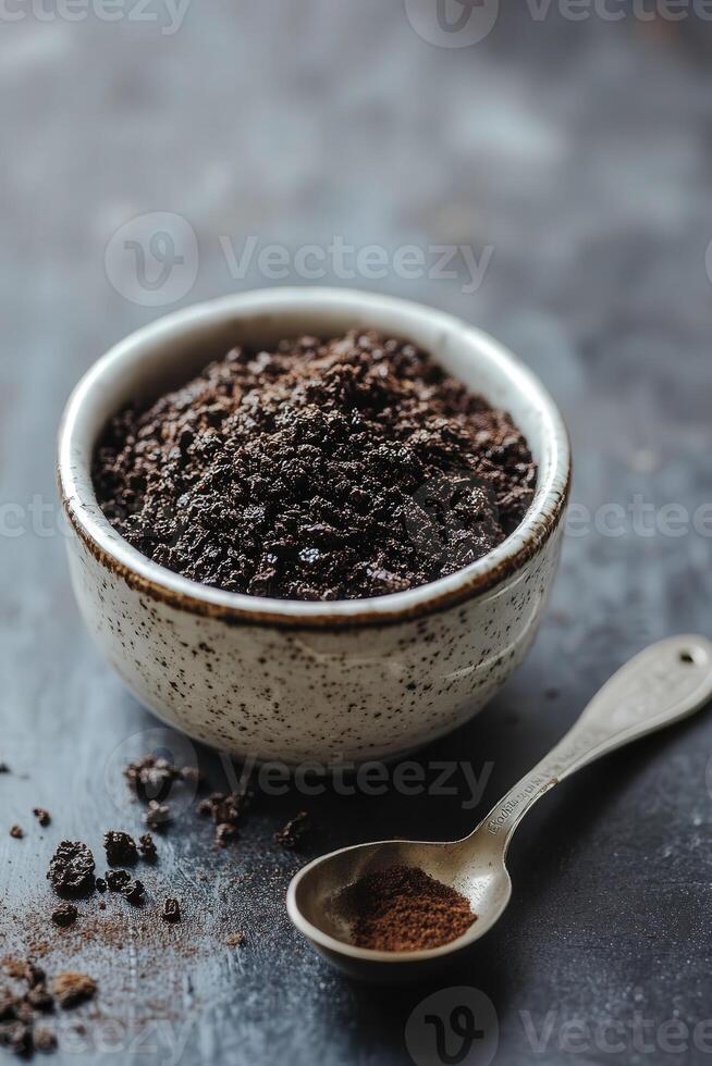 Shilajit powder in a bowl with a spoon on a dark surface photo
