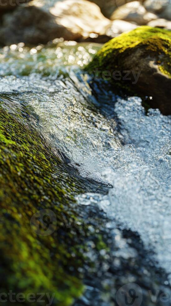 A close up of a stream with water flowing over rocks photo
