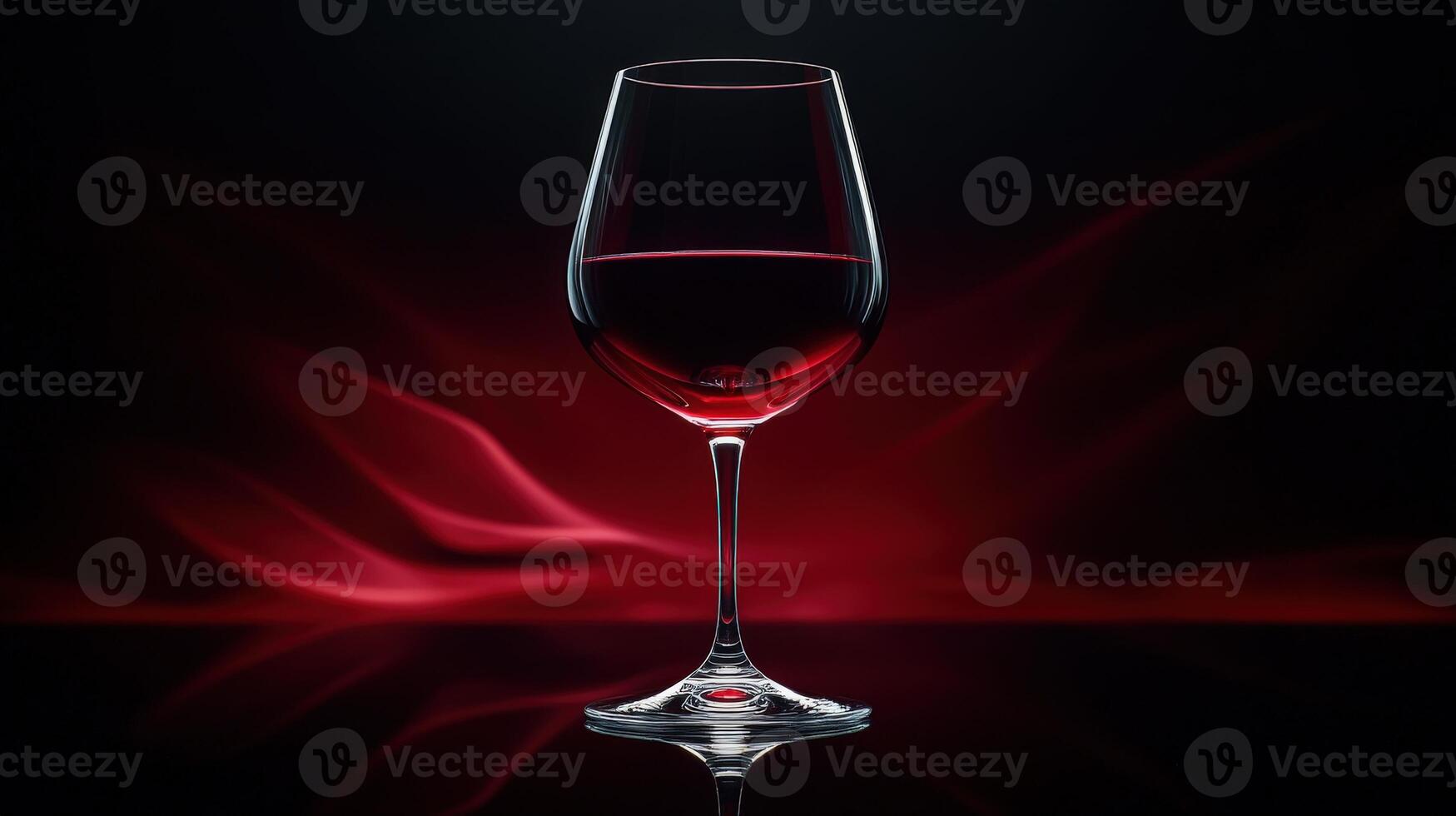 Wine glass filled with red wine on a reflective table with dark background and swirling red light photo