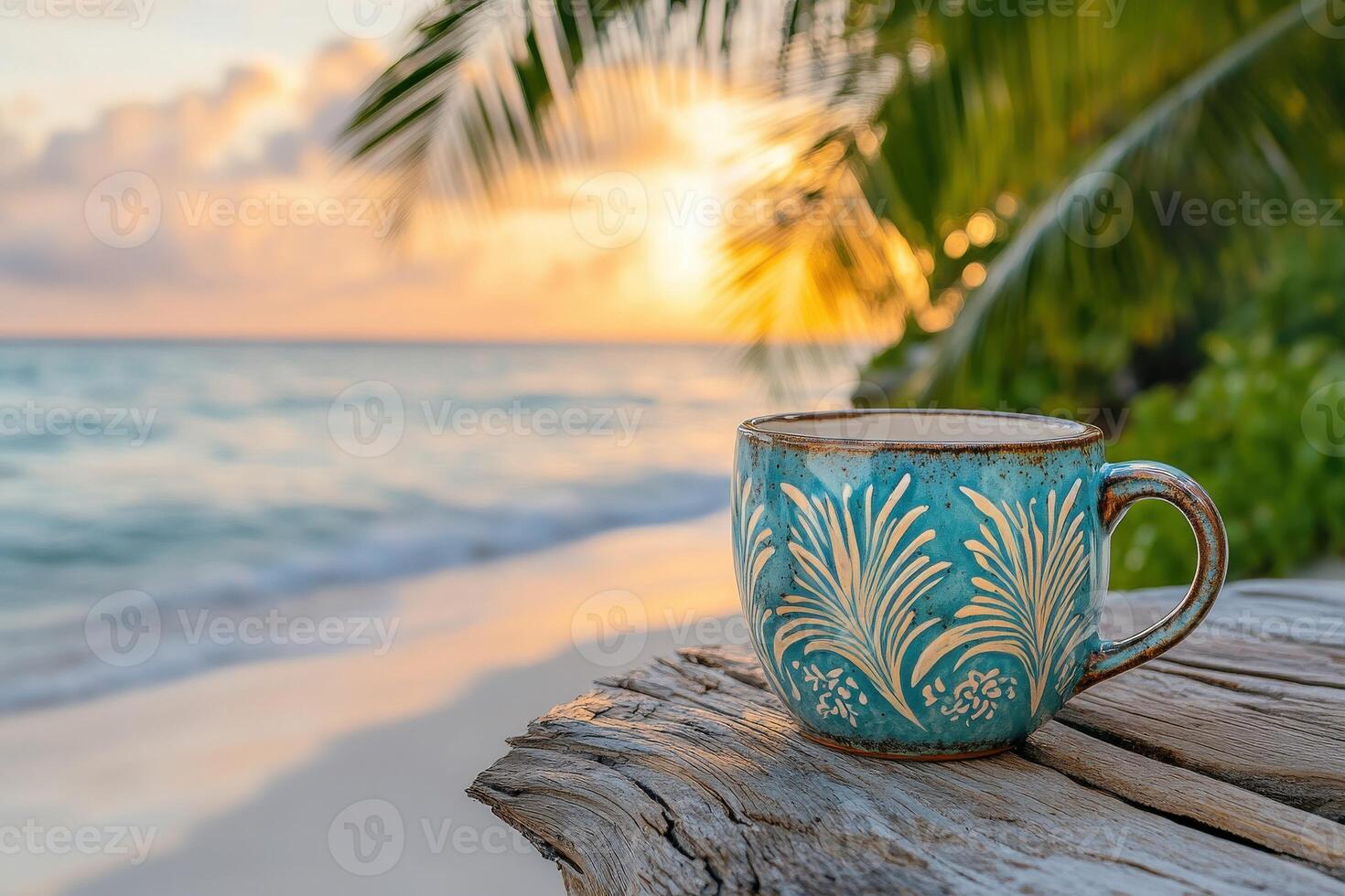 Enjoying a warm cup of coffee by the beach at sunset near tropical palm trees with waves gently lapping the shore photo