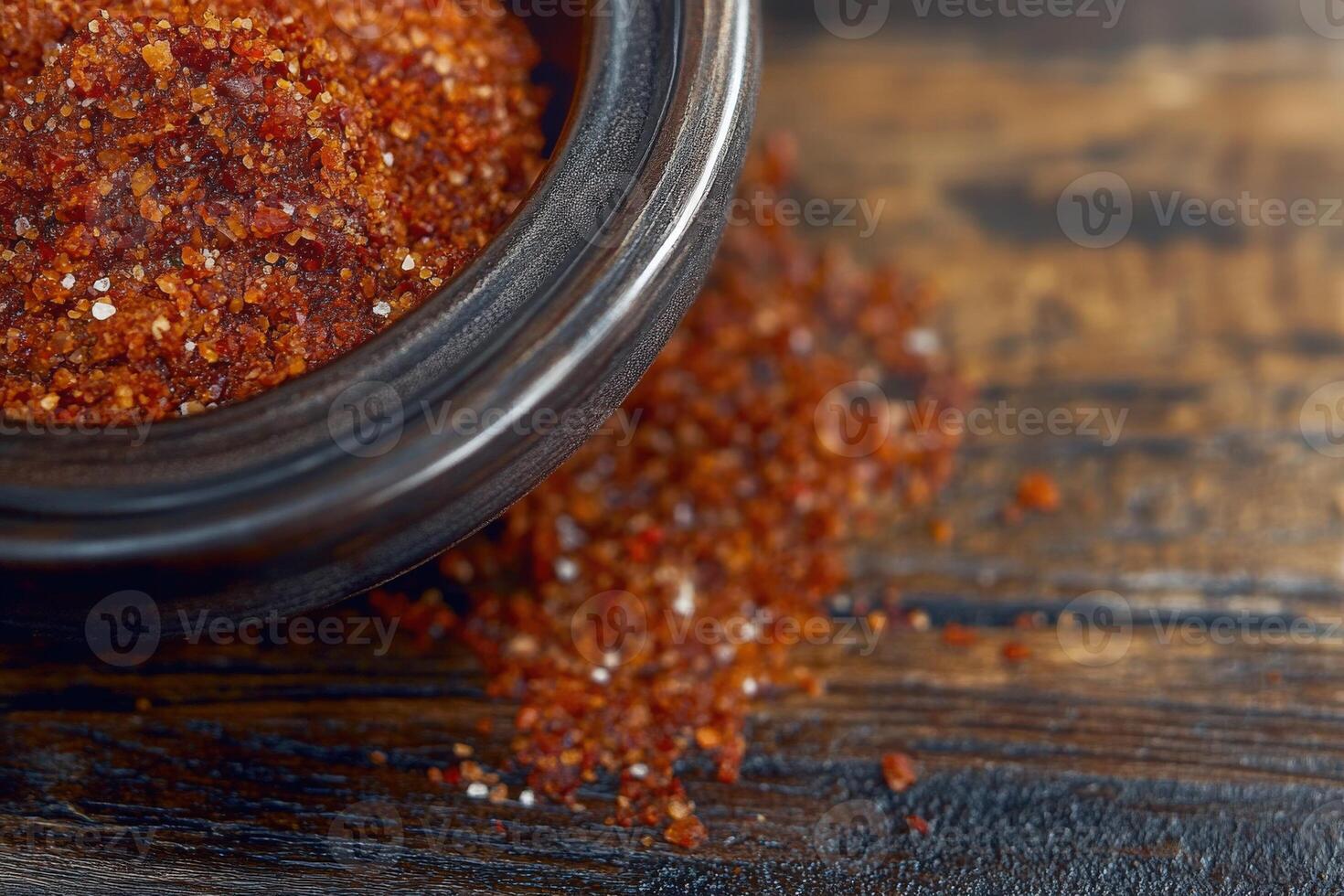 Delicious tajin spice blend sits in a bowl, showcasing its rich, vibrant color and texture on a rustic wooden surface photo