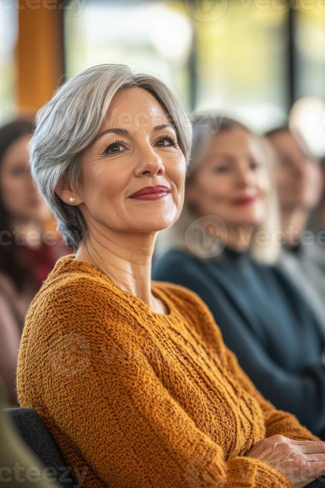 A woman sitting in front of a group of people photo