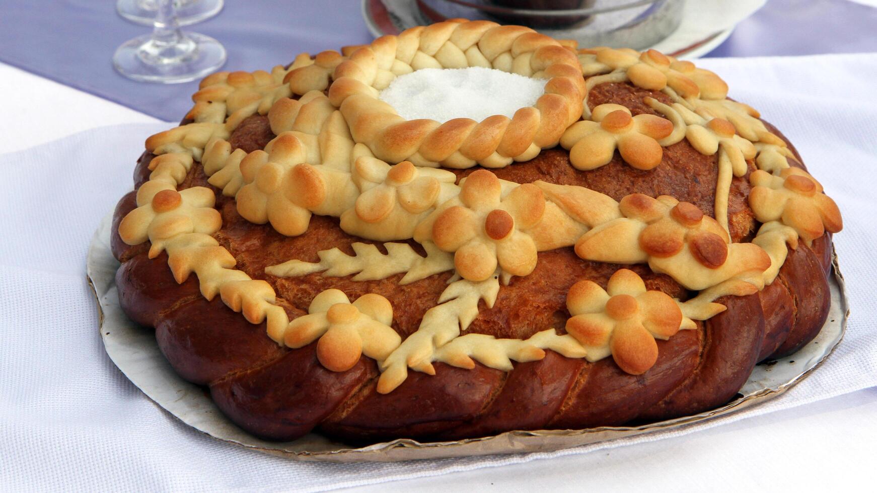 Traditional wedding loaf - a beautiful black bread, decorated with dough patterns in the form of flowers, leaves and braids. photo