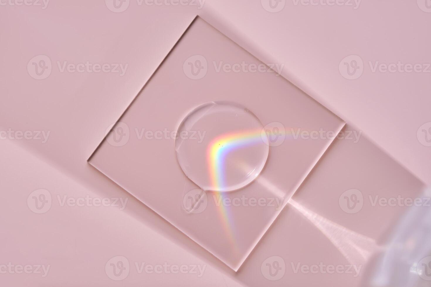A drop of serum on a stand on a pink background with beautiful caustics. photo