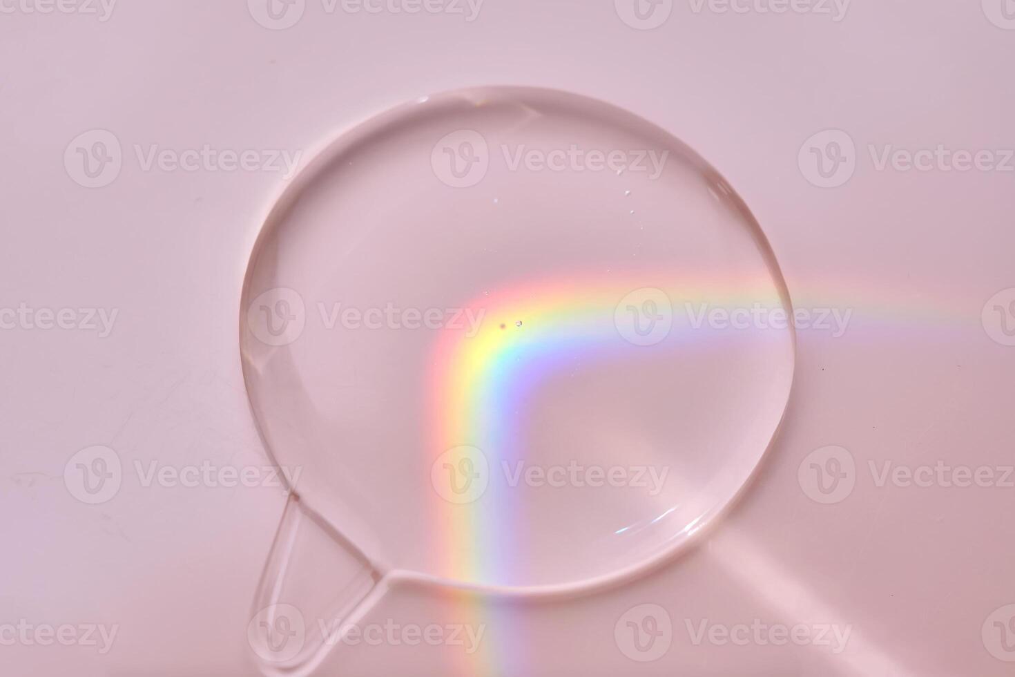 A drop of serum on a pink background with beautiful caustics. photo
