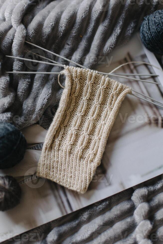 Hand knitted sock with needles and yarn ball. Concept for handmade and hygge slow life. photo