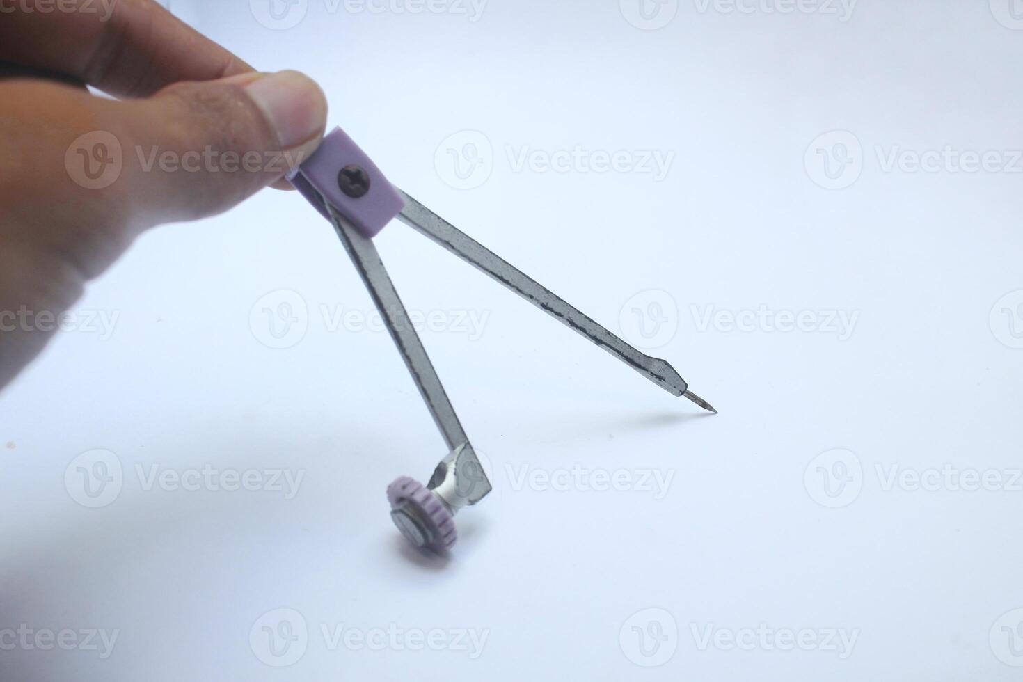 man's hand holding a compass to make a circle, office equipment, equipment for engineers photo