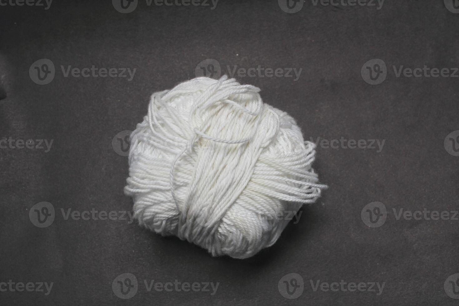 ball roll of white thread for sewing and knitting on black background photo