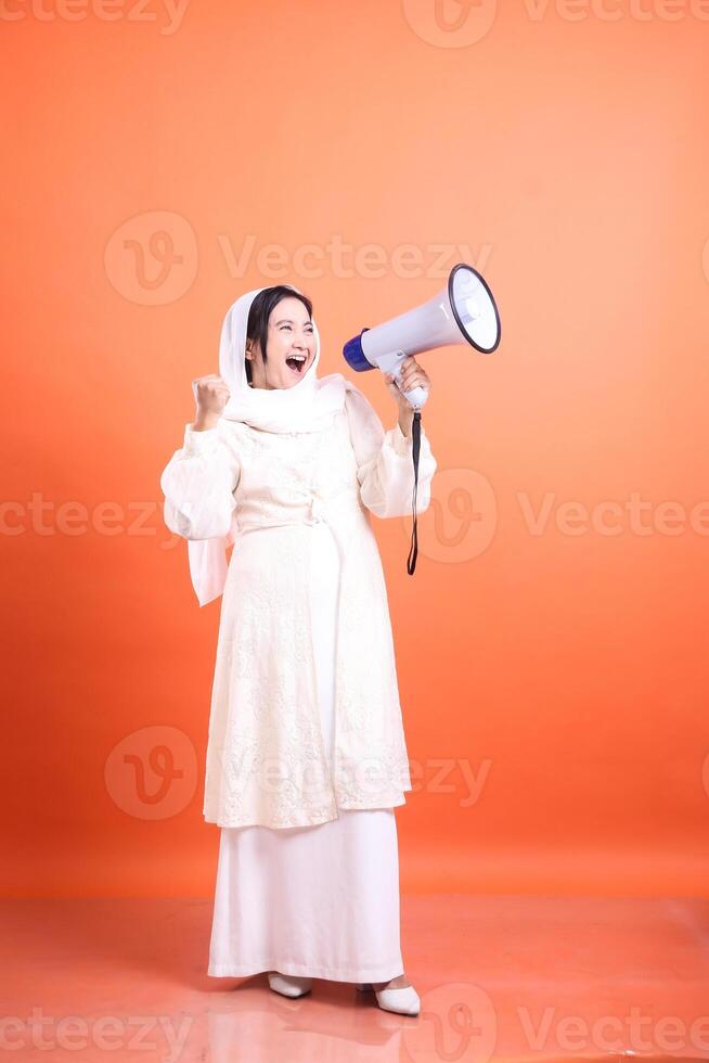 Empowered Voice, Young woman in hijab using megaphone to amplify photo