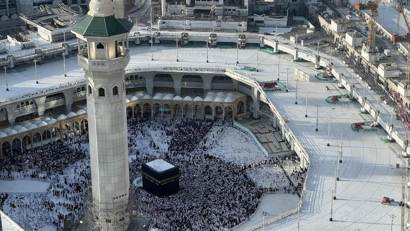 Aerial view of Masjid Al-Haram and Makkah city from the Clock Tower, Pilgrims performing Tawaf around the Kaaba during Hajj or Umrah, Magrib pray. The Holy Mosque, Minarets, and skyline highlight this photo