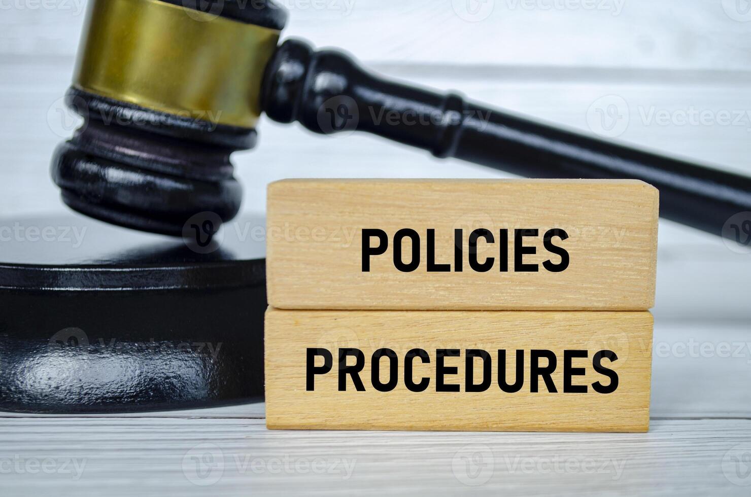 Policies and Procedures text on wooden blocks with lawyer gavel background. photo