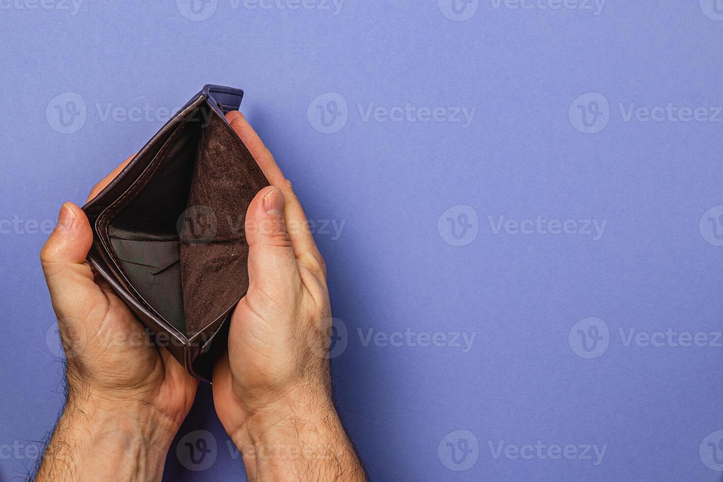 Struggling businessman examines empty wallet during financial crisis photo