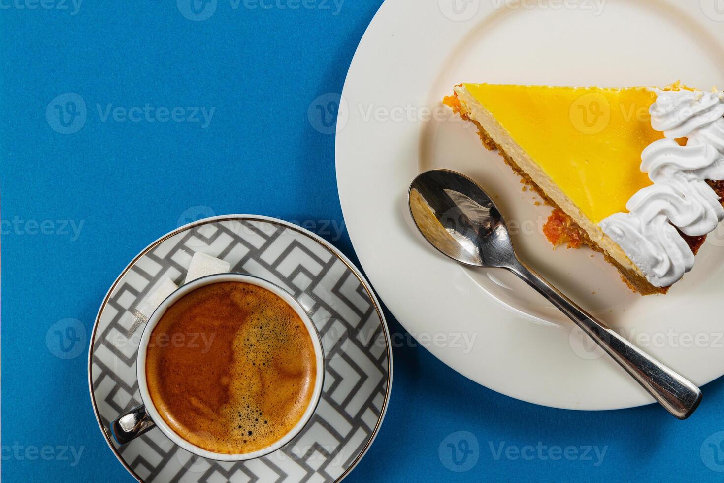 Enjoying a delightful lemon tart with a rich espresso on a bright blue table photo