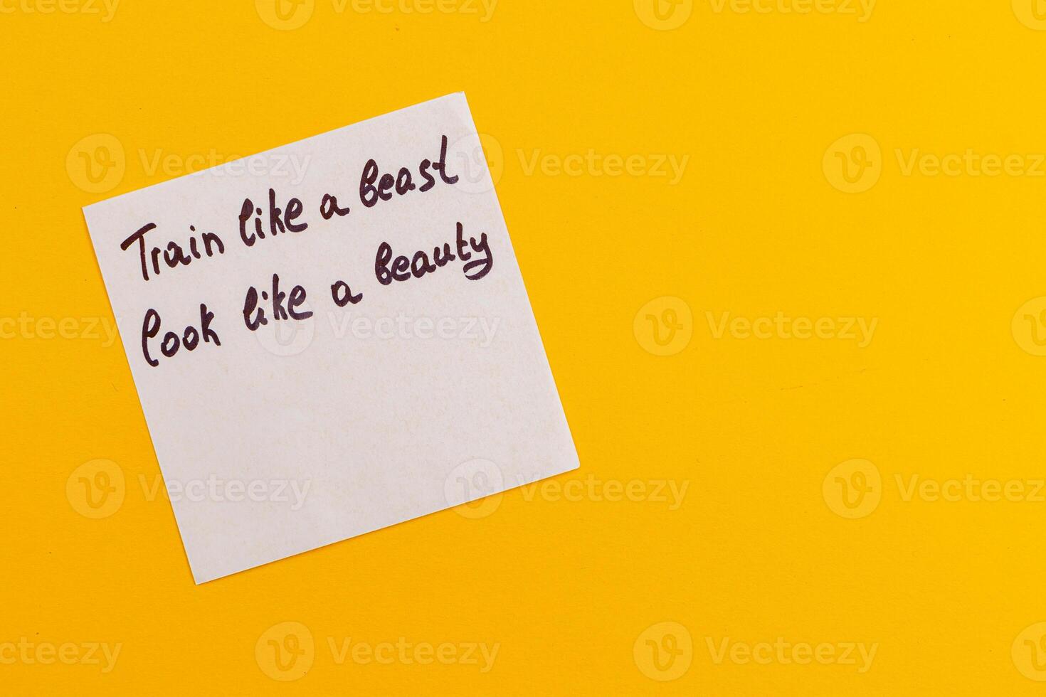 Motivational phrase written on a sticky note against a bright background photo