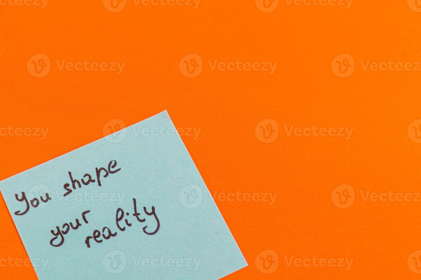 Handwritten motivational note on a vibrant orange background photo