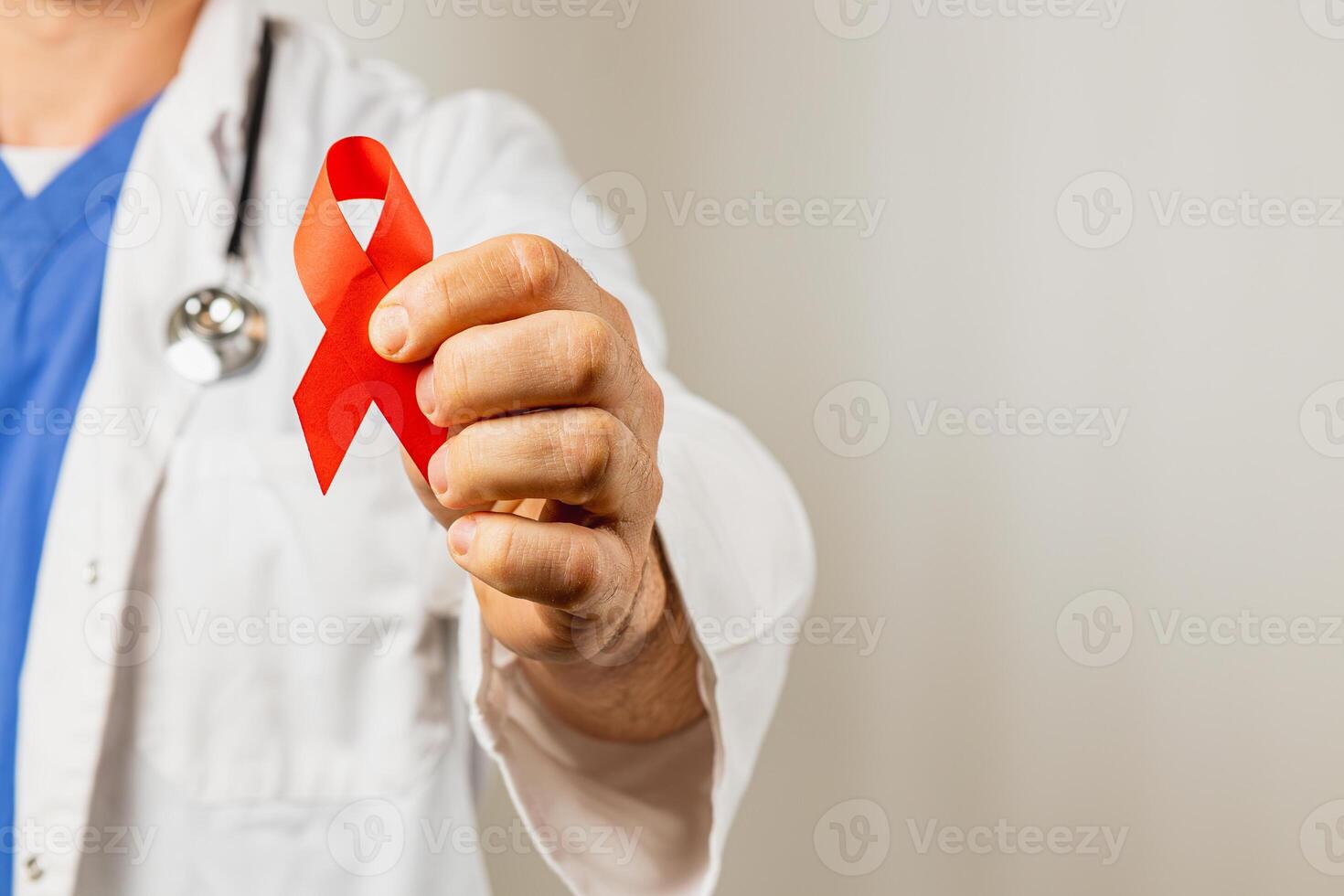 Physician holds red ribbon symbolizing support for HIV awareness campaign photo
