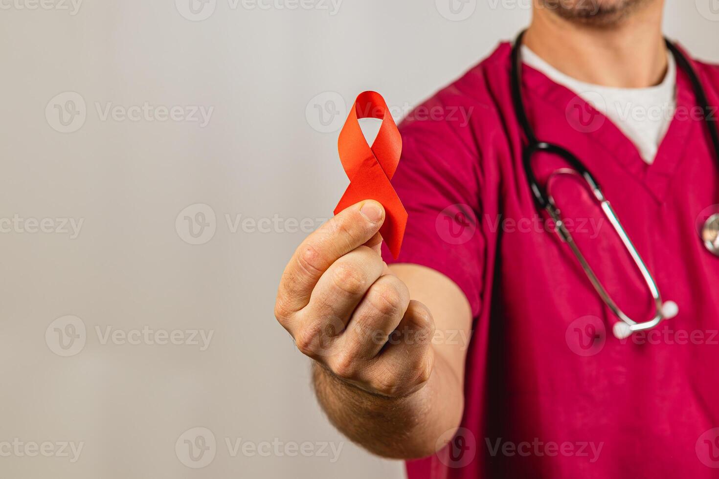 Medical professional holds red ribbon symbolizing HIV awareness during event photo