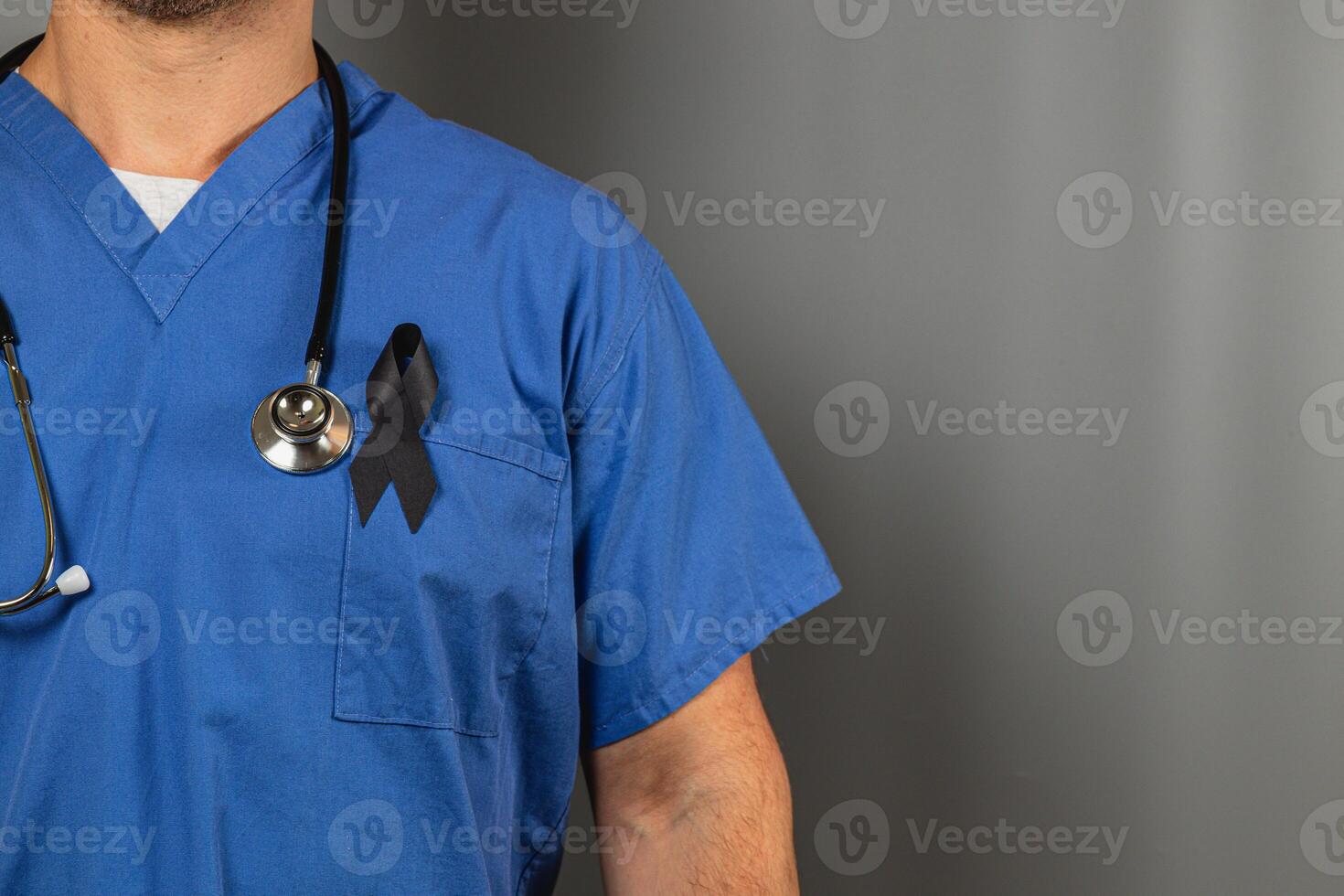 Healthcare worker wearing blue scrubs with black ribbon for mourning photo