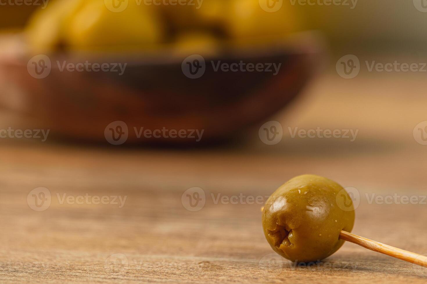 Enjoying green olives on a wooden table with a rustic background photo