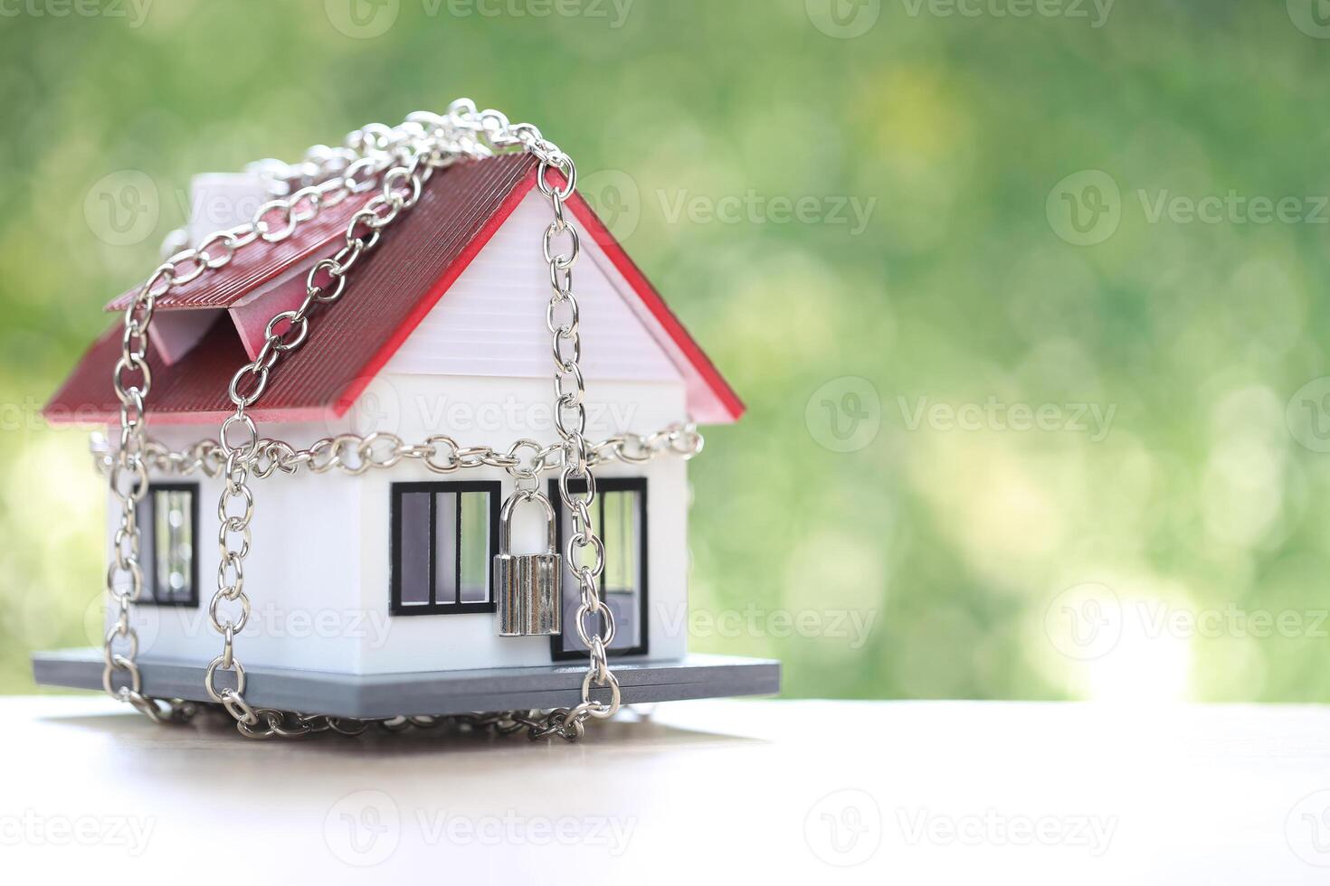 Debt,Locked house with padlock and chain on natural green background,Security and borrow mortgage failure crisis concept. photo