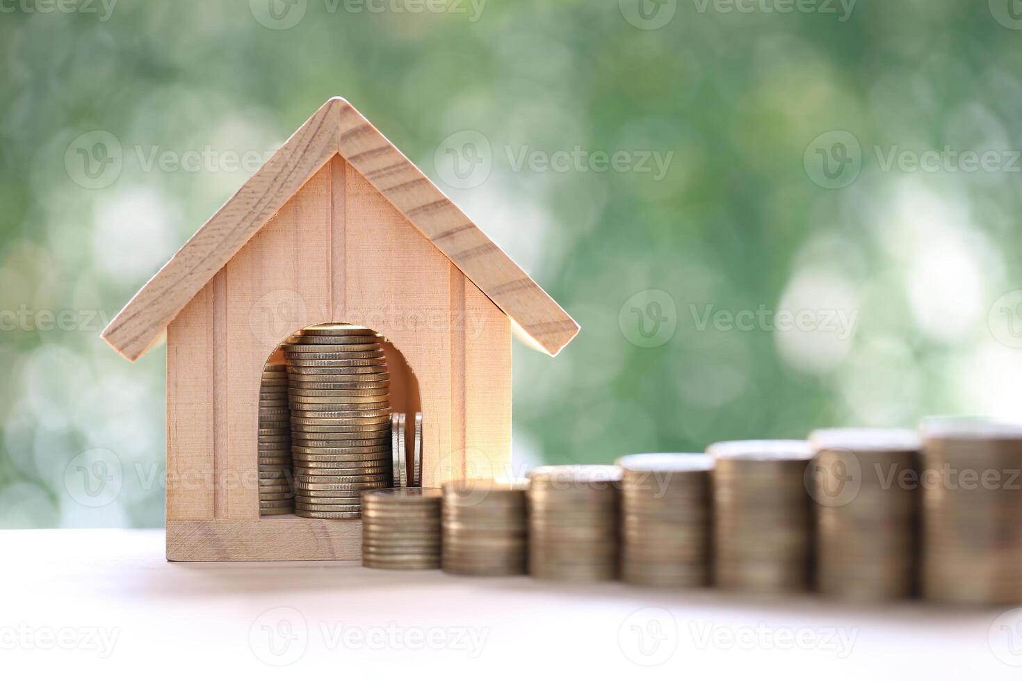Mortgage,Model house and stack of coins money on natural green background,Business investment and Save money for prepare in future concept photo