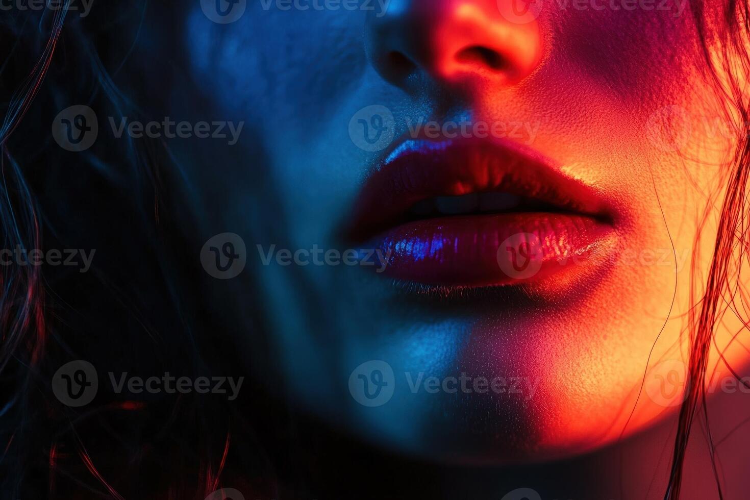 A womans lips are illuminated with vibrant red and blue light photo